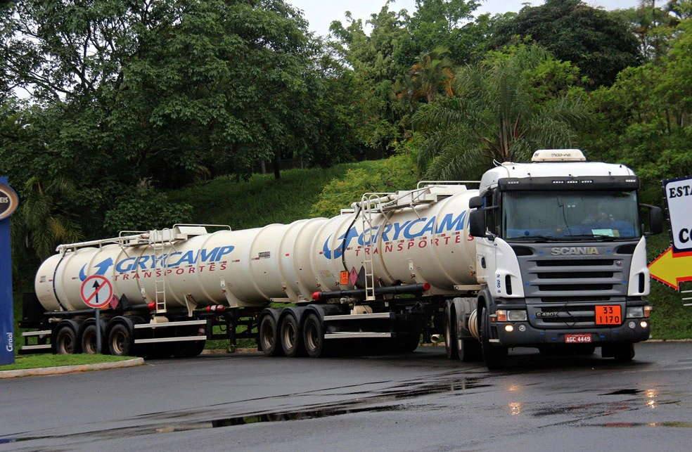 Caminhão Scania da Grycamp transportando carreta tanque em via urbana