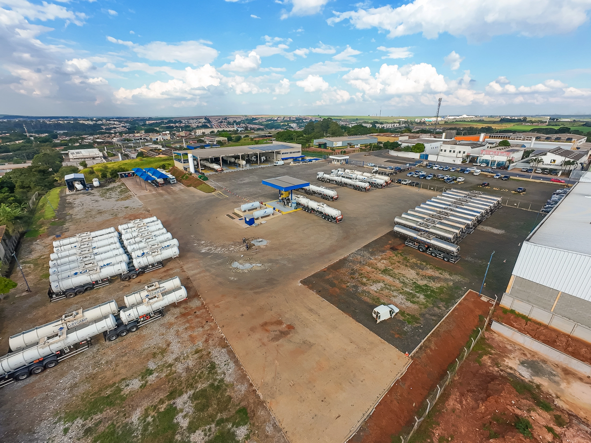 Vista aérea ampla da matriz da Grycamp com frota, pátio e estruturas operacionais