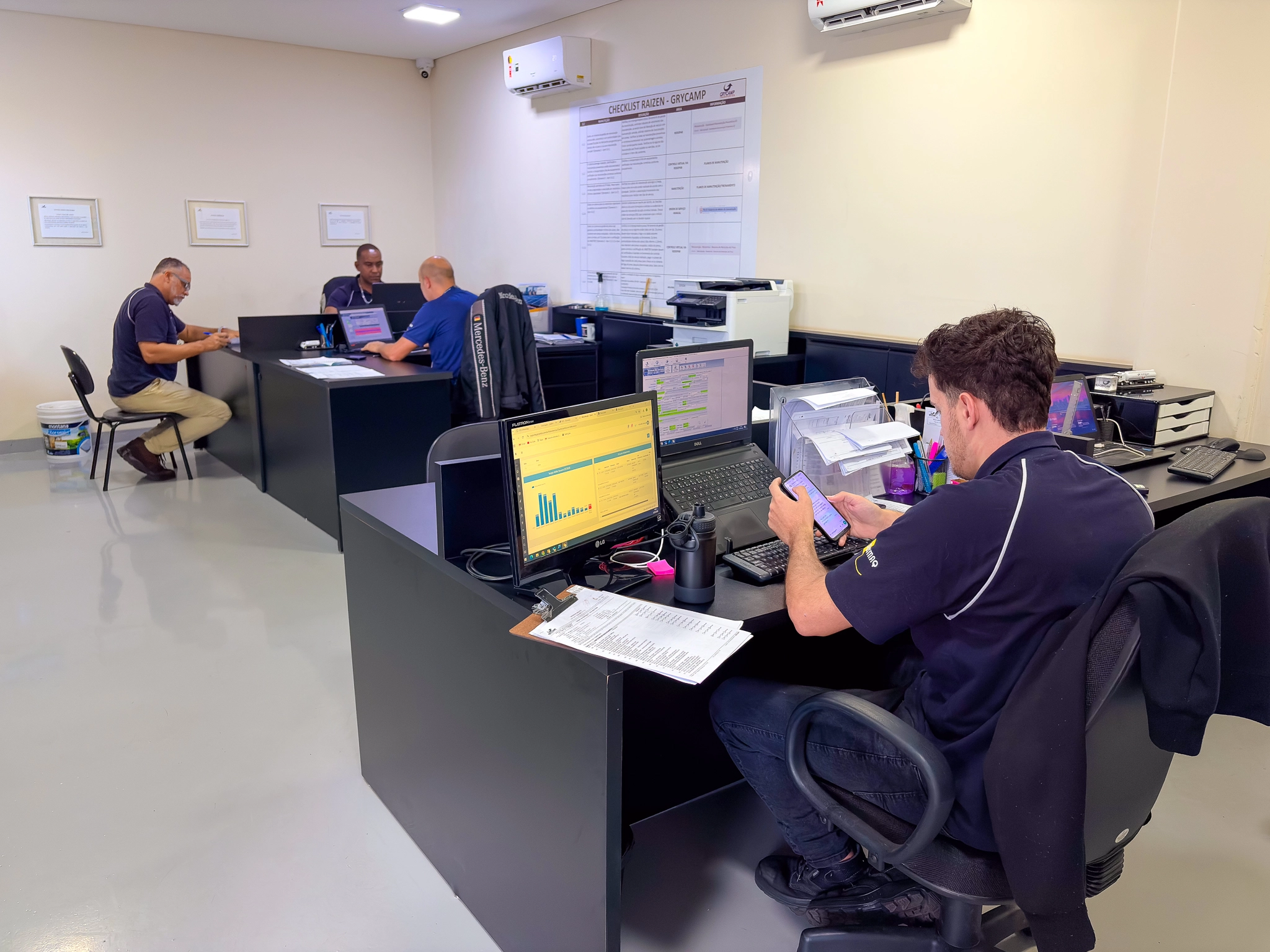 Equipe administrativa da Grycamp trabalhando com computadores e sistemas operacionais